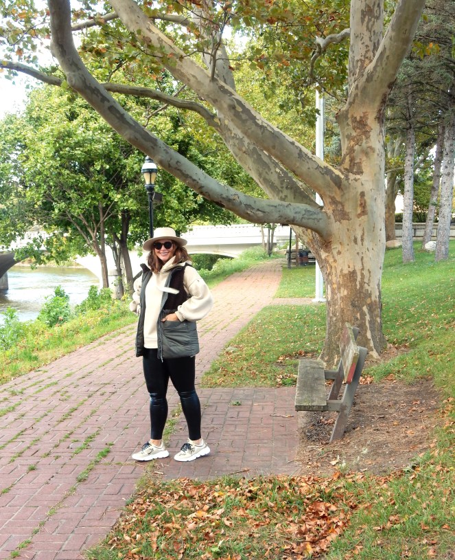 fall fashion with a sherpa vest, chunky gold sneakers, leather leggings, an oversized sweatshirt and felt hat