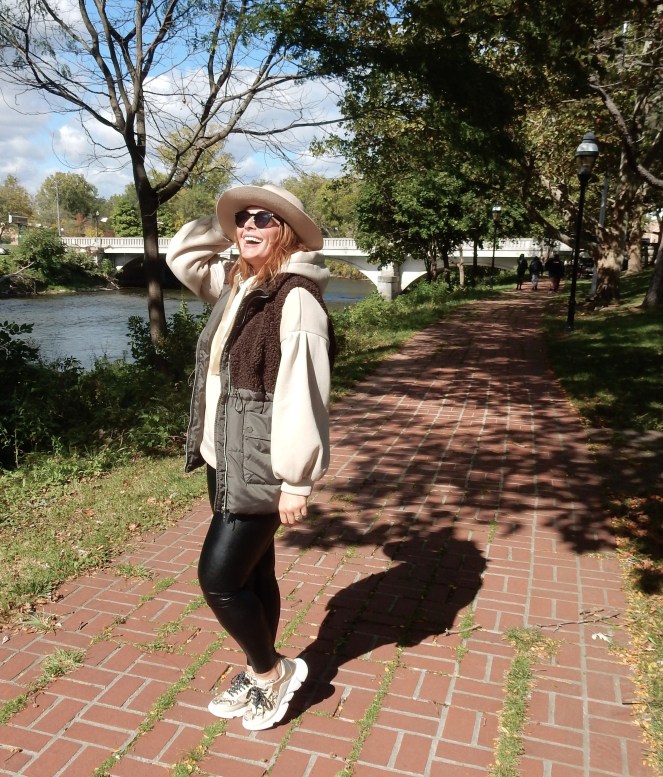 fall fashion with a sherpa vest, chunky gold sneakers, leather leggings, an oversized sweatshirt and felt hat